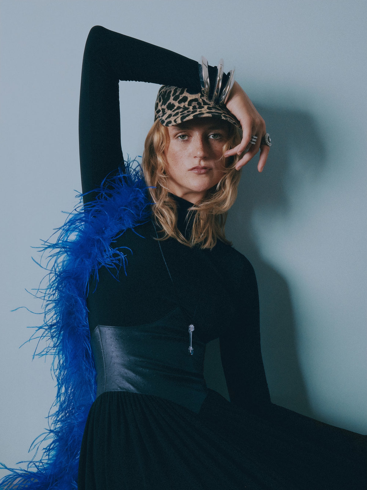 Evening Out - woman in a black dress with a blue feather boa and corset belt